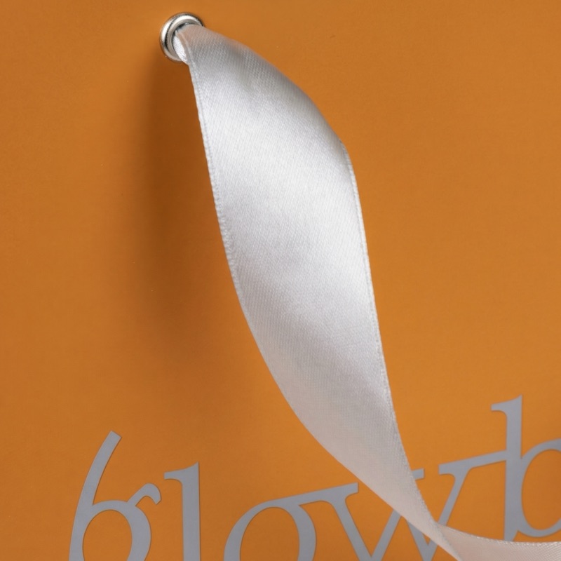 GlowByte — крупный план атласной ленты на оранжевом пакете