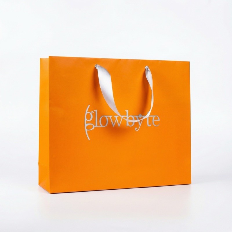 GlowByte — оранжевый бумажный пакет с серебряным логотипом и лентой
