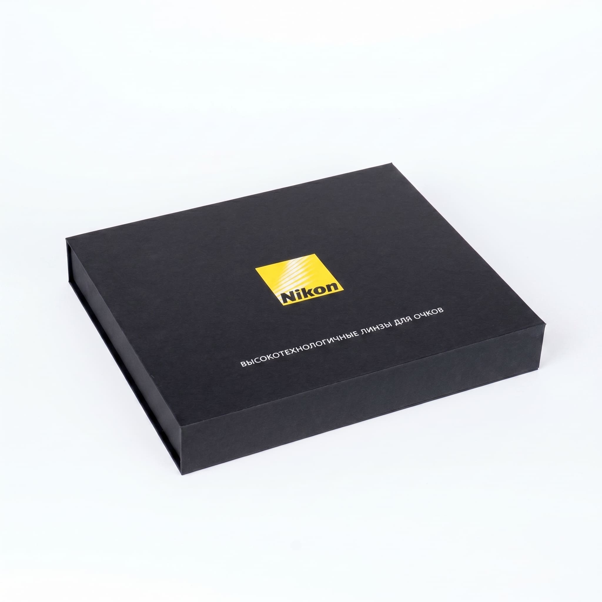 Nikon — чёрная коробка с магнитом с жёлтым логотипом и надписью про линзы для очков