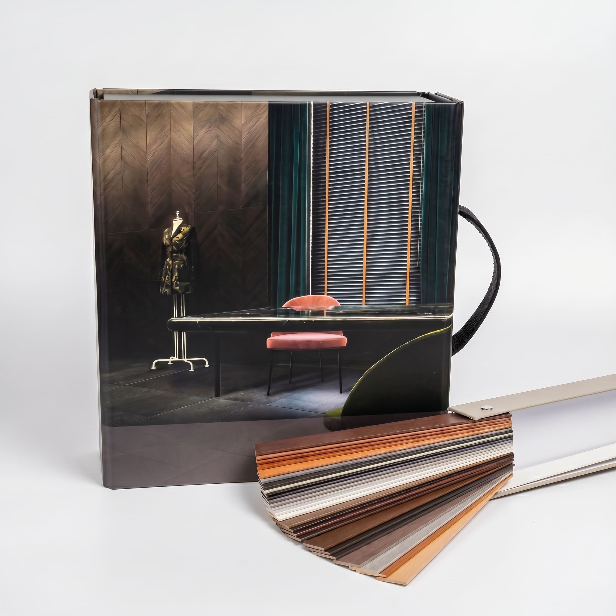 Тёмный сэмпл-бокс с фотографией интерьера и веером образцов жалюзи, тканевая ручка