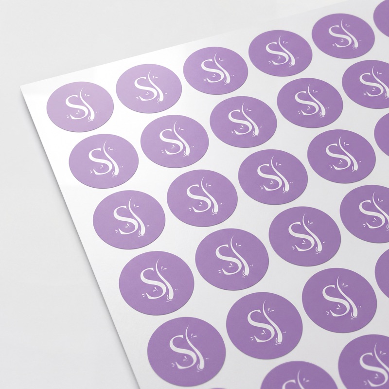 Круглые фирменные наклейки на сиреневом фоне